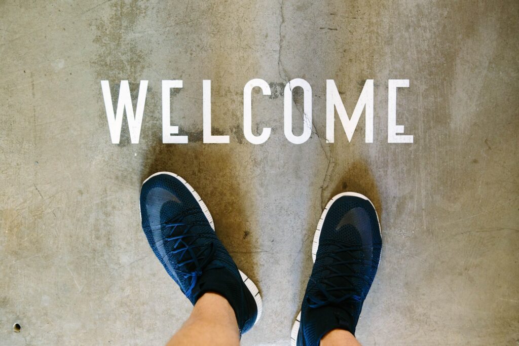 A person's feet in front of a welcome sign.